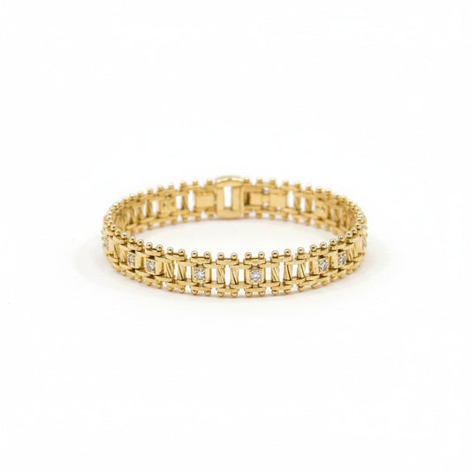 ANIBA JEWELS gold gourmette bracelet with small diamonds and intricate detailing, displayed on a cream stand.