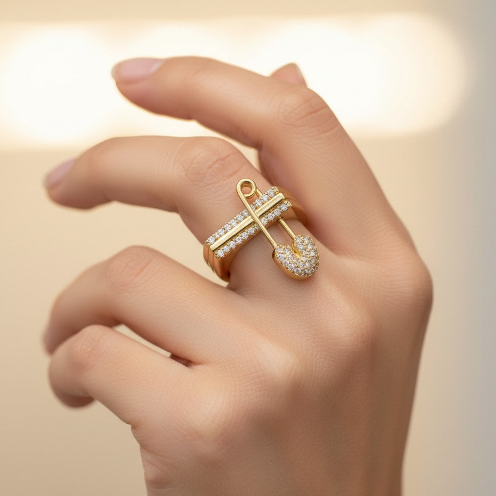 ANIBA JEWELS modern gold ring with a safety pin charm adorned with sparkling stones. Contemporary design.