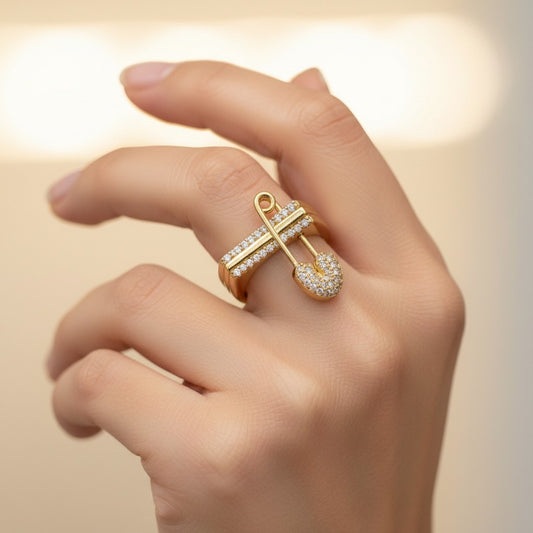 ANIBA JEWELS modern gold ring with a safety pin charm adorned with sparkling stones. Contemporary design.